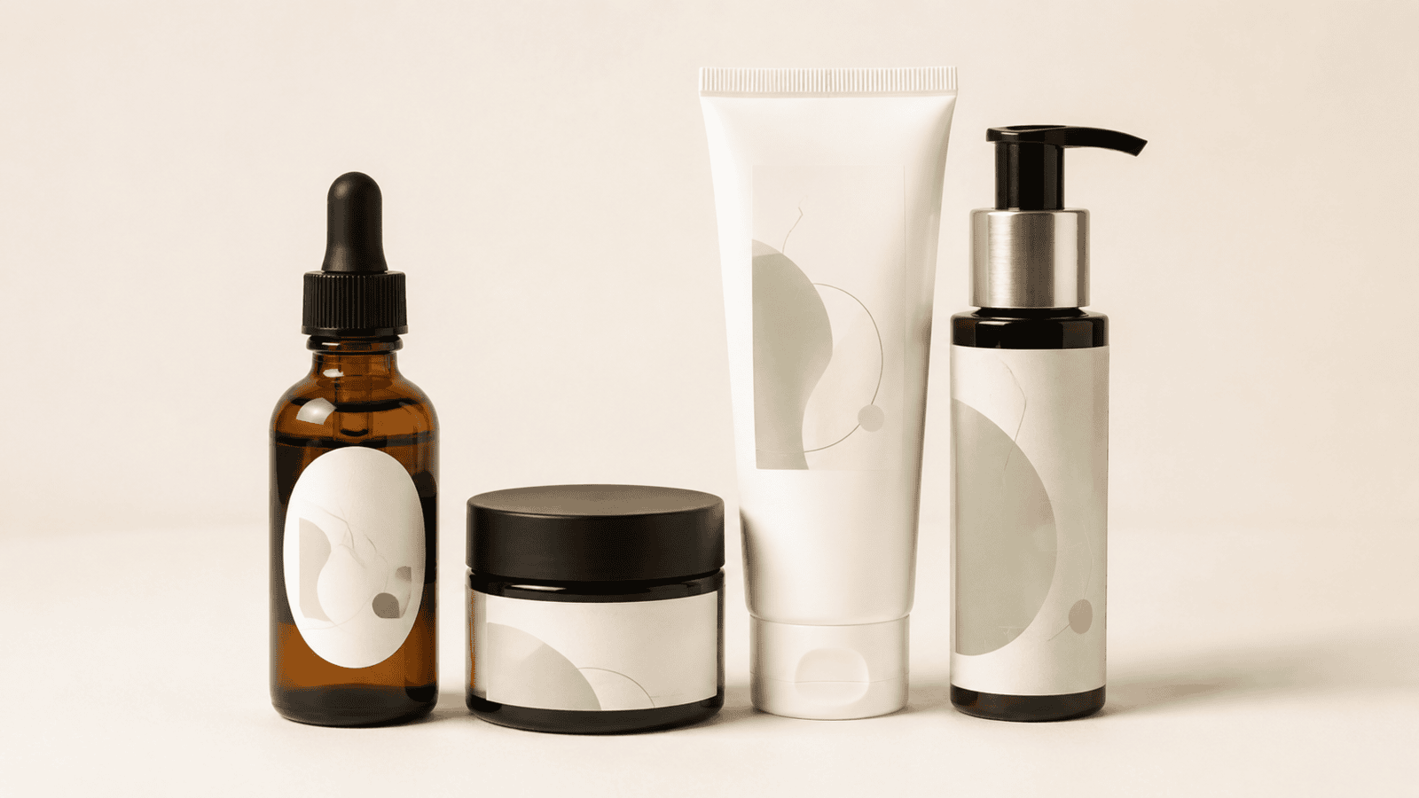 Self-adhesive cosmetic labels on a serum bottle, cream jar, skincare tube, and pump bottle