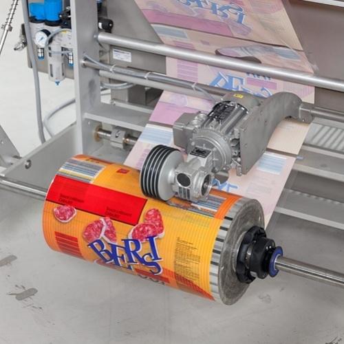 Printed rollstock film running through packaging equipment for pillow pouch production