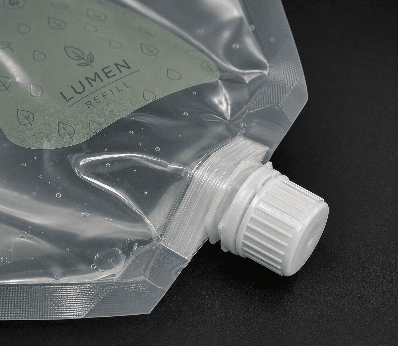 Spout pouch fitment and screw cap for liquid refill packaging Close-up of a liquid refill spout pouch with a screw cap and fitment