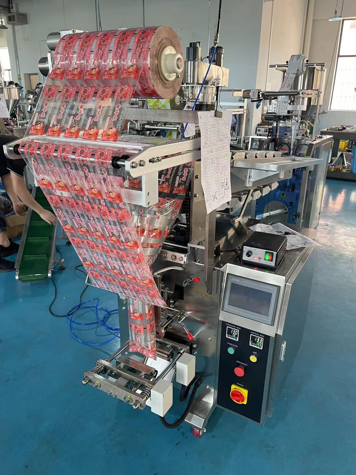 VFFS packaging machine forming pillow pouches from printed rollstock film