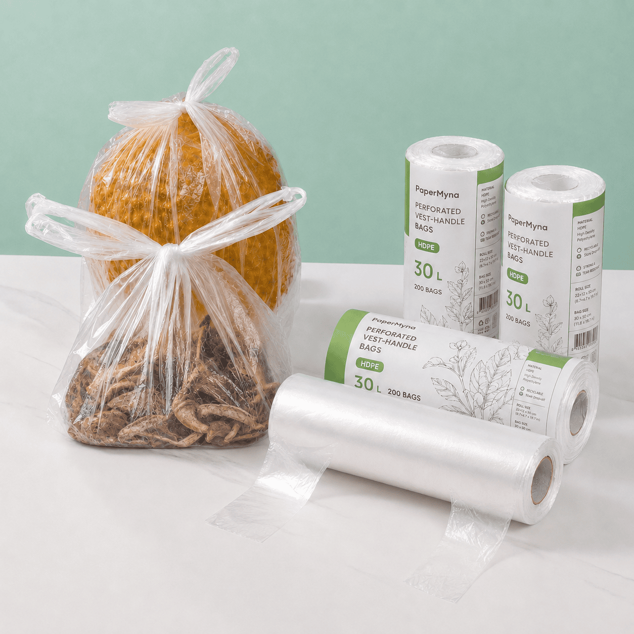 Perforated Vest-Handle Roll Bags PaperMyna perforated vest-handle roll bags with printed paper sleeves, a bare roll and a tied bag for grocery packing.